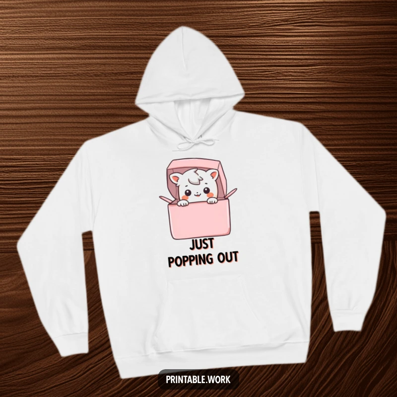 Funny Hoodie: A cute Kawaii character is joyfully peeking out from a vibrant, open box, radiating happiness and warmth.
